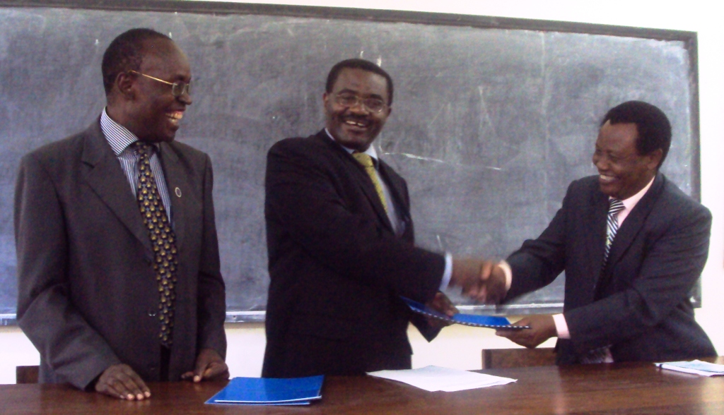 Prof. Twinomugisha (C) exchanges the signed MoU with Prof. Kivaisi (R) as Prof. Tom Otiti (L) witnesses