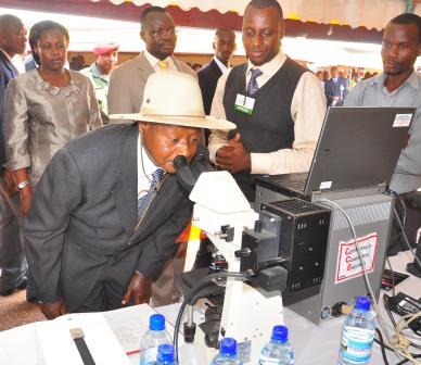 President Museveni visits the CHS display-TB testing in inaccessible areas as Dr. Andrew Kambugu (IDI-Mak) 2nd L, The Vice Chancellor and Minister for Education and Sports (background) take him around
