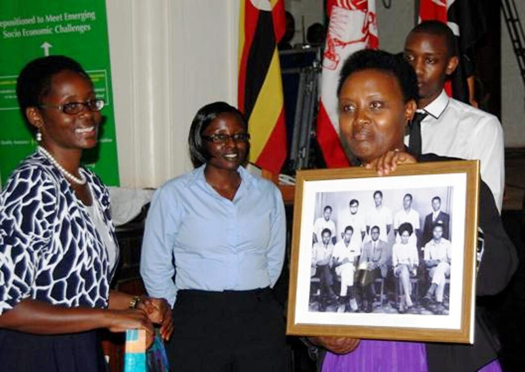 Mrs. Mary Mugyenyi (R) shows off a picture of the 1970 Guild Cabinet that she received as a gift during the lecture.