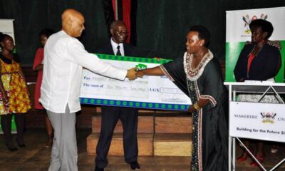 Mrs. Mary Mugyenyi (2nd R) hands over a dummy cheque worth UGX 10m to the Chancellor Prof. George Mondo Kagonyera as Prof. Oswald Ndoleriire-Ag. Principal CHUSS witnesses during the 2nd Joshua Mugyenyi Memorial Lecture, 15th March 2013, Makerere University, Kampala Uganda.