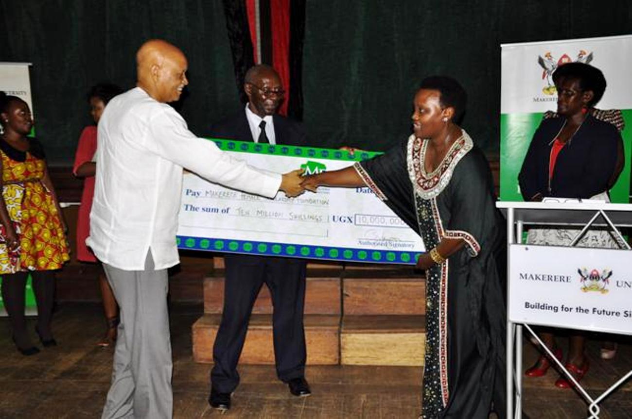 Mrs. Mary Mugyenyi (2nd R) hands over a dummy cheque worth UGX 10m to the Chancellor Prof. George Mondo Kagonyera as Prof. Oswald Ndoleriire-Ag. Principal CHUSS witnesses during the 2nd Joshua Mugyenyi Memorial Lecture, 15th March 2013, Makerere University, Kampala Uganda.