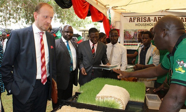 Swedish Ambassador to Uganda, H.E Urban Andersson (L) accompanied by Dr. George Nasinyama-DRGT and Prof. Mukadasi Buyinza-Director DRGT tour the exhibition during the Science Day on 19th Nov 2013, CoVAB, Makerere University, Kampala Uganda