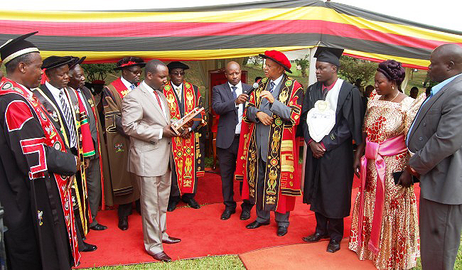 Mr. Bruce Kabaasa, Chairperson Convocation (with plaque) prepares to hand over the Best Humanities Award to Mr. Engotoit Bernard (3rd R) at the 63rd Graduation Ceremony on 25th Jan 2013, Makerere University, Kampala Uganda