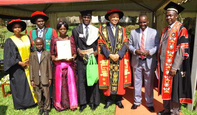 The best Humanities Student Mr. Kabuye Frank (C), poses with Family, MUBS Staff, Chancellor-Prof. G. Mondo-Kagonyera (3rd R) Chairman Convocation-Mr. Bruce Kabaasa (2nd R) and Academic Registrar-Mr. A. Masikye Namoah at the 64th Graduation Ceremony, Makerere University, Kampala Uganda