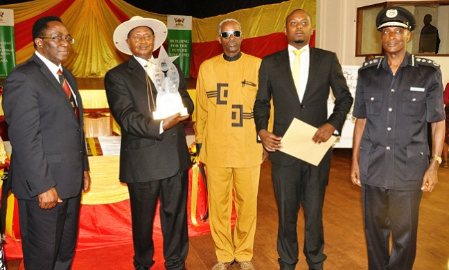 President Yoweri Museveni shows off his award presented at the GLSU Second Convention, 7th June 2014. Alongside H.E. are VC-Prof. J. Ddumba-Ssentamu (L), GLSU Patron-Gen. Elly Tumwine (C), GLSU Chairperson-Mr. David Lewis (2nd R) and IGP-Gen. Kale Kayihura (R) at Makerere University Main Hall, Kampala Uganda.