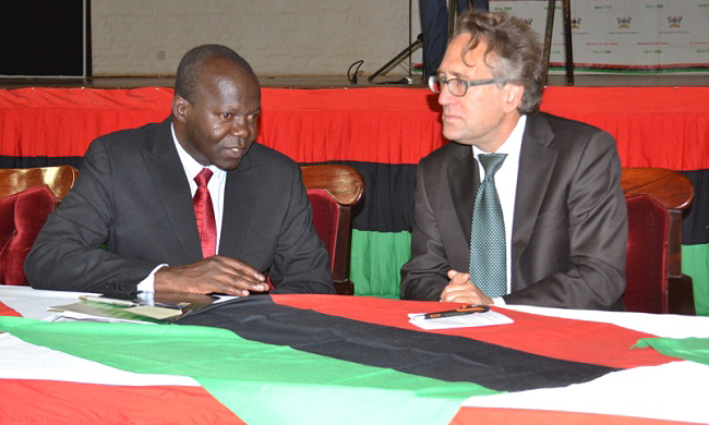 The Deputy Vice Chancellor in charge of Academic Affairs Dr. Ernest Okello Ogwang (L) chats with Prof. Dr. Daniel Wyler-Vice President for Medicine and Science, University of Zurich during the One-Health Symposium, 7th to 8th July 2014, Makerere University, Kampala Uganda