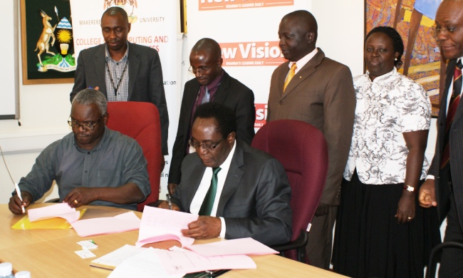 Vision Group CEO-Mr. Robert Kabushenga (L) and Vice Chancellor Prof. John Ddumba-Ssentamu flanked by R-L Senior Legal Officer-Mr. Goddy Muhumuza, Deputy Principal CoCIS-Dr. Agnes Rwashana Semwanga and Principal CoCIS-Dr. C. Okello Obura and Vision Group Staff sign the MoU on 1st July 2014, Vision Group Premises, Kampala Uganda