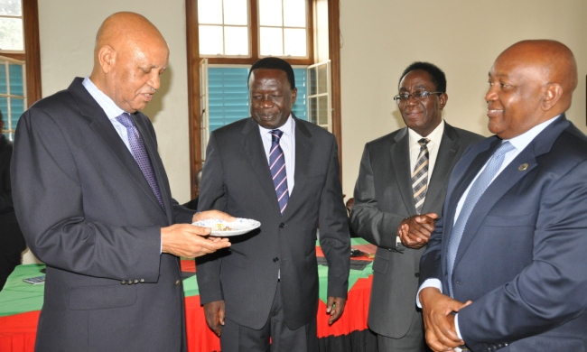 The Chancellor-Prof. George Mondo Kagonyera (L) prepares to pin a lapel badge on Mak Holdings Board of Directors Chairman-Mr. Charles Mbire (R) as Chairperson Council-Eng. Dr. Charles Wana Etyem (2nd L) and Vice Chancellor-Prof. John Ddumba-Ssentamu (2nd R) witness during the Inauguration Ceremony, 22nd August 2014, Makerere University, Kampala Uganda