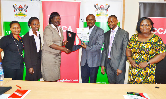 Head of ACCA Uganda, Ms Beatrice M. Isagayite and The Ag. Principal, CoBAMS, Dr. Eria Hisali exchanging Signed MoUs as Dr Umar Kakumba and  Dr. Bernadette Nambi Karuhanga look on.