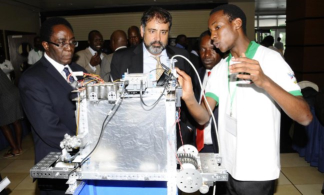 L-R VC-Prof. J. Ddumba-Ssentamu, Dr. Alex Deghan-Director, Office of Science and Technology, USAID and Prof Willaim Bazeyo-Dean, School of Public Health, CHS/RAN Chief of Party appreciate a robotic demonstration by a student at the RAN launch 4th June 2013, Sheraton Kampala Hotel, Uganda