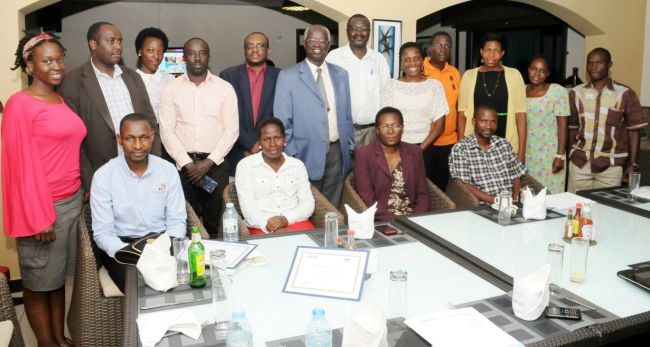 Sitting L-R: Dr. Innocent Rwego-Univ of Minnesota, Dr. Shamilah Namusisi-Pioneer Resident, Dr. Jesca Nakavuma-Deputy Principal CoVAB, Dr. David Muwanguzi-Pioneer Resident with Dr. Geoffrey Kabagambe-Program Manager OHCEA Uganda (Centre-Blue Jacket), Prof. Francis Ejobi (Next) and officials from CoVAB, Univ. of Minnesota at the Pioneer Award Cereomony, 1st April 2015, Kampala Uganda