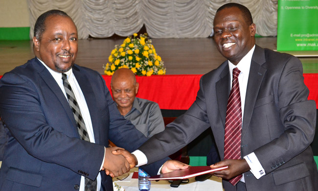 Mr Didas Nkurunziza (L) handing over to Mr George Omunyokol (R), the incoming Chairperson of the Makerere University Staff Tribunal.