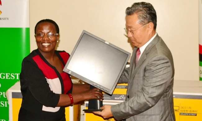 Amb. Park Jong-Dae(R) hands over a Monitor as part of the 10 PC donation to Dr. Alison Kinengyere on 6th May 2015, Korea Corner, MakLIB, Makerere University, Kampala Uganda
