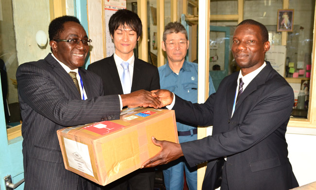 Prof. John Ddumba-Ssentamu (L) handing over equipment to Mr. Kirabo Joseph looking on is Mr. Hashimoto Jin and Mr. Shinsuke Iwama respectively.