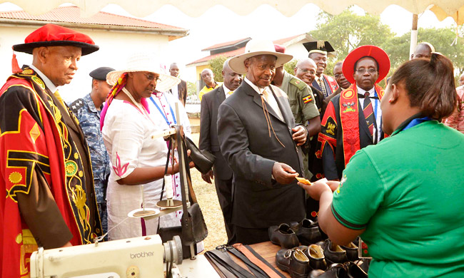 President Museveni (Centre) and First Lady Janet Museveni admires some of the leather products at the graduation ceremony. Extreme left is Chancellor Prof. Mondo Kagonyera and extreme right is Prof. David Kabasa.