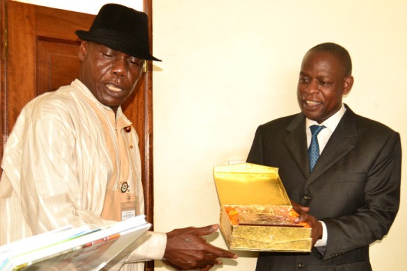 Dr. Ssembatya (R) receives a plaque on behalf of the Vice Chancellor from National Institute for Policy and Strategic Studies.