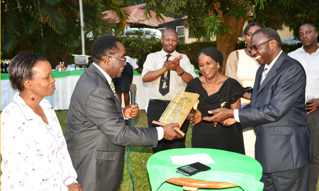 The Vice Chancellor Prof. John Ddumba-Ssentamu hands over a plaque from the Directorate of Human Resources. Looking on (left) is Mrs Mary Tizikara, Director of Human Resources