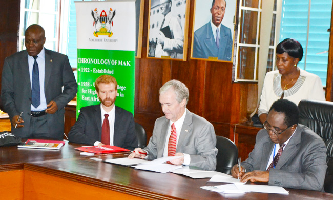 Vice Chancellor Prof. John Ddumba-Ssentamu(R) and Dr. Jeffery Braden on his right sign the MoU in the Council Room. Looking on is Ms Martha Muwanguzi, extreme left is the University Senior Legal Officer Mr Goddy Muhumuza.