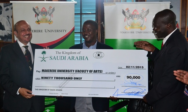 The Ambassador of Saudi Arabia to Uganda H.E Dr. Jamal Rafah, handing over the cheque  to the the Acting Vice Chancellor and Deputy Vice Chancellor in charge of Academic Affairs, Dr. Ernest Okello Ogwang. In the middle is the Coordinator of Arabic Language Mr. Ssali Ebraheem