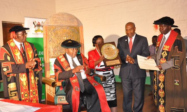 (L-R) Ag. Chancellor and Vice Chancellor Prof. John Ddumba-Ssentamu, Prof. Emmanuel Tumusiime-Mutebile and wife Mrs. Betty Mutebile (holding a plaque),the Prime Minister, Rt. Hon. Ruhakana Rugunda representing His Excellency Yoweri Kaguta Museveni and Deputy Vice Chancellor (Academic Affairs) and Dr. Okello Ogwang who read the Certificate of Award.