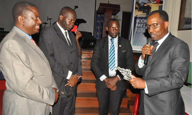 Mr. Richard Byarugaba (Right) among winners who scooped Appreciation Award giving his acceptance speech. On his right is Guild President David Bala Bwiruka. Looking on is the Dean of Students Mr Cyriaco Kabagambe (L) and Assoc. Prof. Ernest Okello Ogwang acting Vice Chancellor.