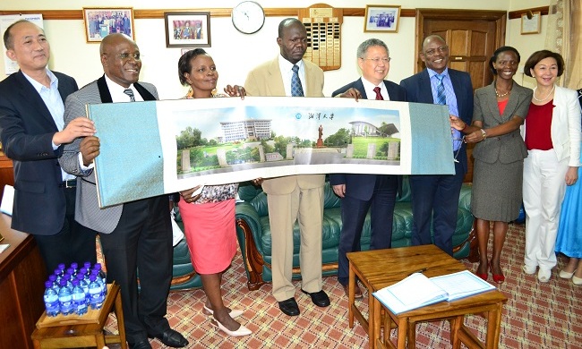 The Acting Vice Chancellor Dr. Okello Ogwang together with the Makerere University team receive a souvenir from the President of Xiangtan University, Prof. Huang Yunqing.