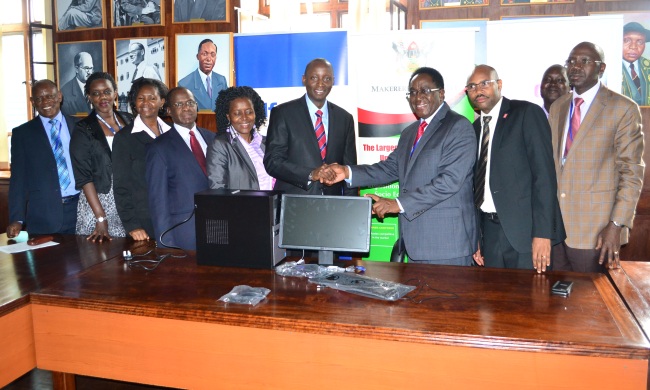 The Vice Chancellor-Prof. John Ddumba-Ssentamu (3rd R) receives the PC Donation from DFCU's Head of Corporate Banking-Mr. William Sekabembe as DVCFA-Prof. Barnabas Nawangwe (Left), University Secretary-Mr. Charles Barugahare (2nd R), Mak and DFCU staff witness.