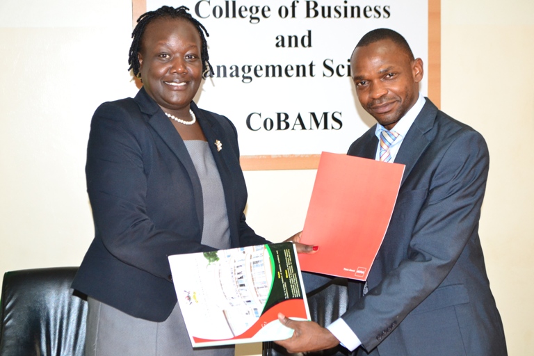 Ms. Beatrice Isagayite exchanging the MoU with Dr. Umar Kakumba.