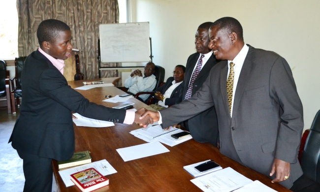 The Dean of Students-Mr. Cyriaco Kabagambe (R) congratulates The Guild Electoral Commission Chairperson-Mr. Isaac Otuku (L) after his swearing in ceremony as The Deputy Dean of Students-Mr. Stephen Kateega (2nd R) and Hall Wardens witness, 6th March 2017, Makerere University, Kampala Uganda