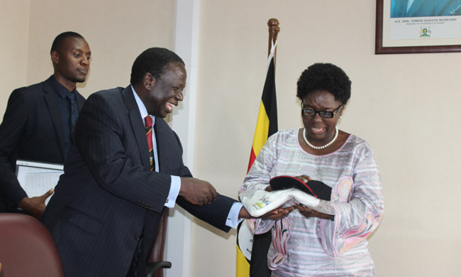 The Speaker of Parliament, Hon. Rebecca Kadaga receiving her kit as Chief Runner from the Chairperson of Makerere University Council Eng. Dr. Charles Wana Etyem
