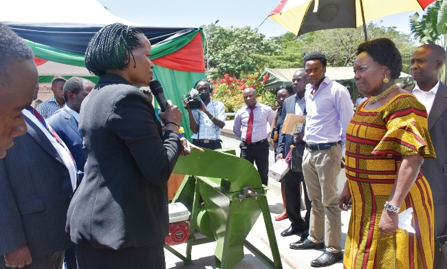 The Speaker of Parliament-Rt. Hon. Rebecca Kadaga (R) listens to Ms. Harriet Adong-RAN (2nd L) during a tour of one of the RAN Innovation Exhibitions