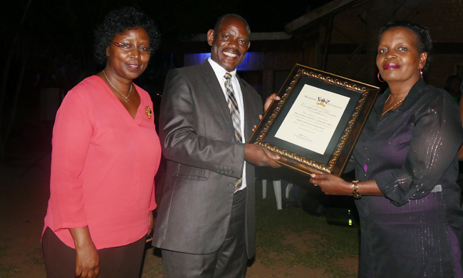 Prof. Barnabas Nawangwe, the Deputy Vice Chancellor for Finance and Administration flanked by Mrs. Dorothy Sennoga-Zake, the Acting Director- Human Resources handing over a Certificate of Service to the outgoing Director Mrs. Mary K. Tizikara