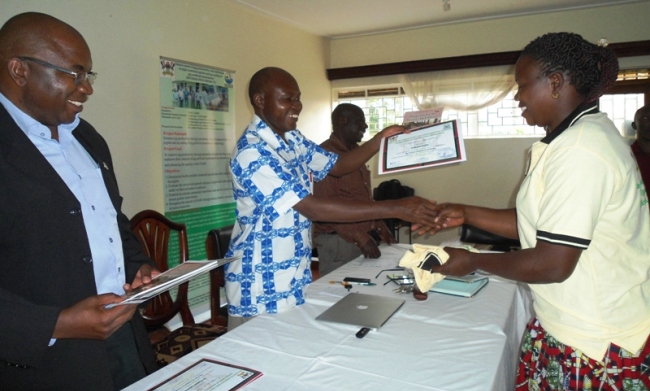 Project PI Assoc. Prof. Donald  R. Kugonza (L) and Prof. David Owiny hand over a certificate of attendance to one of the participants after the training held at the Makerere University Agricultural Research Institute Kabanyolo (MUARIK), CAES, Makerere University, Wakiso Uganda