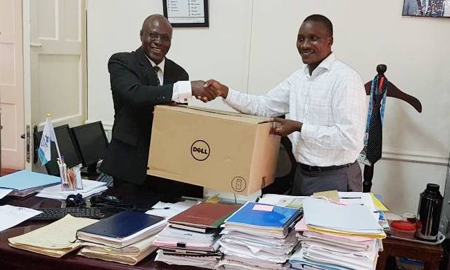 Ag. Director Legal Affairs-Mr. Goddy Muhumuza (L) receives the PC donation from Dr. Bruce Kirenga, 28th September 2017, Directorate of Legal Affairs, Makerere University, Kampala Uganda
