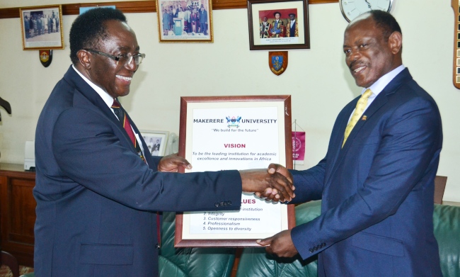 The Outgoing VIce Chancellor-Prof. John Ddumba-Ssentamu (L) hands over the University Vision, Mision and Core Values to Incoming Vice Chancellor-Prof. Barnabas Nawangwe (R) during the ceremony, 31st August 2017, Makerere University, Kampala Uganda