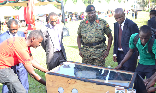 The Chief Guest Lt. Gen. Charles Angina (Centre) admire a solar dryer at the Expo.