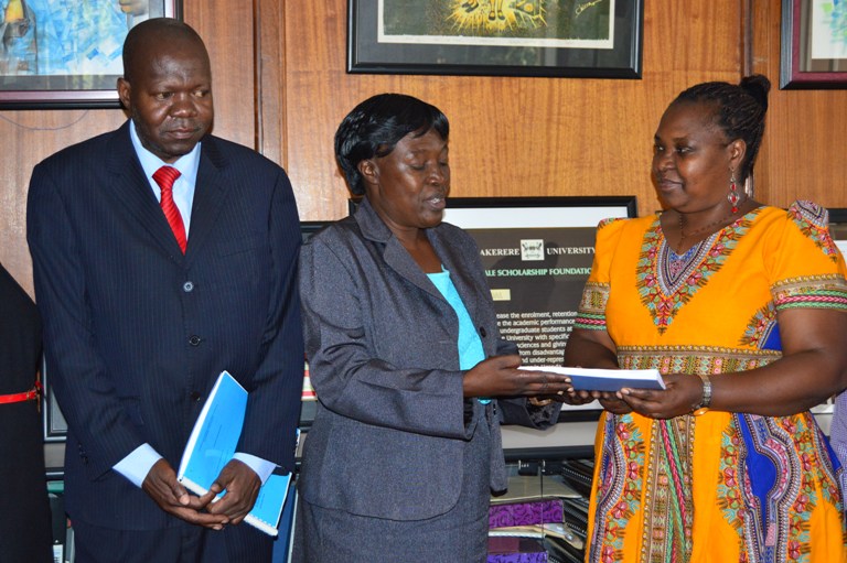 Ms. Frances Nyachwo presenting the handed over report to  the newly-appointed Acting Director Dr. Euzobia Mugisha Baine, left is the Deputy Vice Chancellor for Academic Affairs Dr. Ernest Okello Ogwang.