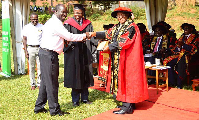 The Chancellor-Prof. Ezra Suruma (R) shakes hands with Chairman Convocation-Dr. Odoi Tanga (2nd L) as Principal CAES-Prof. Bernard Bashaasha (2nd R) and MUASA Chairman & Convocation PRO-Dr. Kamunyu Muhwezi (L) witness, 16th January 2018, Makerere University, Kampala Uganda. Prof. Bashaasha received the best overall science student award plaque and UGX1million from Makerere University Convocation on behalf of Mr. Odongo Brian Boniface-BSc. Food Science and Technology.
