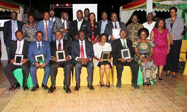 Former MakSPH Leaders, L-R: Front-Prof. David Serwadda, Prof. William Bazeyo, Prof. Gilbert Bukenya, Prof. Josephine Nambooze (3rd R), Prof. John Tuhe Kakitahi and Prof. Fred Wabwire-Mangeni (Rear 5th R) with Chairperson Council-Eng. Dr. Charles Wana-Etyem (C), current Dean-Dr. Rhoda Wanyenze (R) and other members of Council and Management at the Commemorative Dinner, 20th December 2017, Kololo, Kampala Uganda. The success of MakSPH over the years has been as a result of successive good leadership.