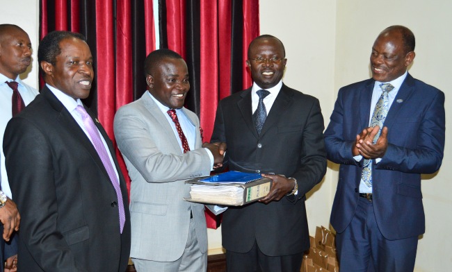 The Outgoing MUASA Chairperson-Dr. Muhammad Kiggundu-Musoke (2nd R) hands over to Chairperson-Elect Dr. Deus Kamunyu Muhwezi (2nd L) as Vice Chancellor Prof. Barnabas Nawangwe(R) and Deputy Vice Chancellor (Finance and Administration) Prof. William Bazeyo (L) witness, 15th January 2018, Senior Common Room, Main Building, Makerere University, Kampala Uganda.