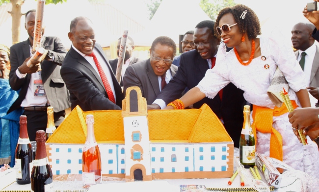 The Chancellor & Guest of Honour-Prof. Ezra Suruma (2nd L) joined by Chair Council-Eng. Dr. Charles Wana-Etyem (3rd L), Vice Chancellor-Prof. Barnabas Nawangwe (L) and his wife Mrs. Susan Nawangwe (R) cuts the ceremonial cake at the thanksgiving celebrations commemorating Prof.Nawangwe's election as Vice Chancellor. Prof. Nawangwe hosted clergy and guests to a colourful ceremony held on 6th January 2017 in Busiwondo Village, Busia District and received recognition from the Council and his Sirwa clan