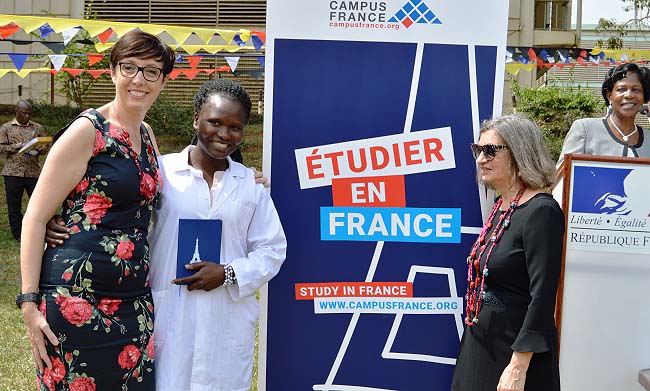 H.E. Stéphanie Rivoal (L) embraces Ms. Anena Juliet (2nd L), shortly after awarding her the French Scholarship as Director of Campus France, Ms. Béatrice Khaiat (2nd R) and Ms. Martha Muwanguzi (R) witness, 30th January 2018, Freedom Square, Makerere University, Kampala Uganda