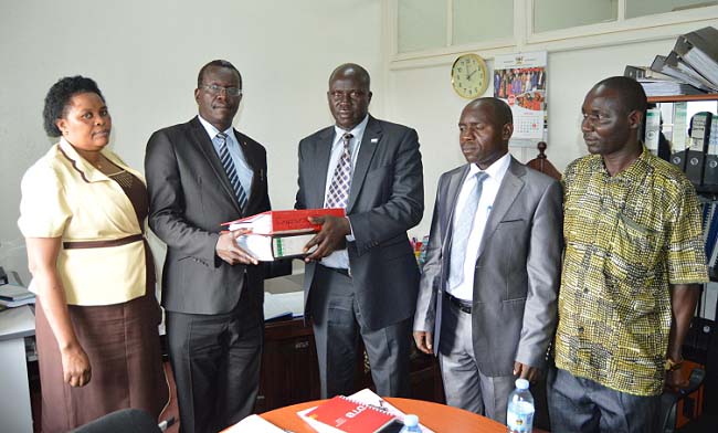 Mr. Benson Barigye (C) symbolically hands over files to the substantive Director, Internal Audit-Mr. Walter Yorac Nono (2nd L) as L-R: Ms. Komugisha Consolate, Mr. Ssanyu Lawrence and Mr. Patrick Akonyet witness during the ceremony held in the Directorate Offices, Main Bulding, Makerere University.