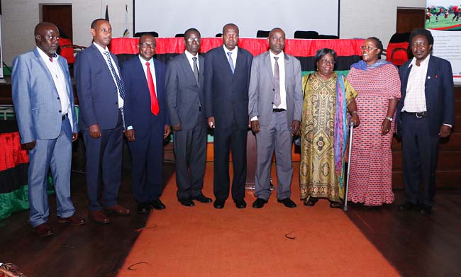 The Chief Guest-Mr. Mukwatampola Muzamir (4th R) representing Hon. Dr. J.C. Muyingo poses for a group photo with L-R: Dr. Edgar Nabutanyi, Assoc. Prof. Aaron Mushengyezi, Keynote Speaker-Prof. Peter Wasamba, Prof. Edward Kirumira, DVCAA-Assoc. Prof. Ernest Okello Ogwang, Hon. Mrs. Joyce Mpanga, Assoc. Prof. Josephine Ahikire and Assoc. Prof. Patrick Mangeni at the CHUSS Symposium, 6th March 2018, Makerere University, Kampala Uganda