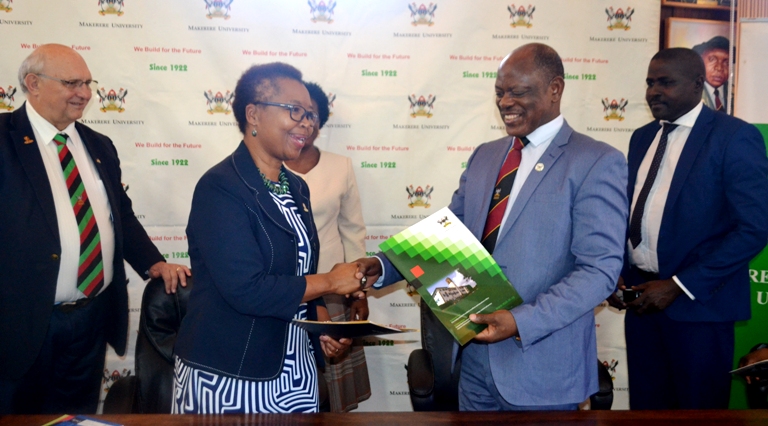 Vice Chancellor of Makerere University Prof. Barnabas Nawangwe exchanging the MoU with   the Vice Chancellor of Nelson Mandela University Prof Sibongile Muthwa. Witnessing, is the Senior Director at Nelson Mandela University Prof. Nico Jooste  and  the Director of Legal Affairs Mr. Henry Mwebe.