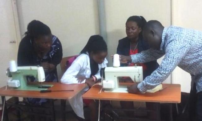 An instructor shows students how to use the motorised tailoring machines at DACE, CEES, Makerere University, Kampala Uganda