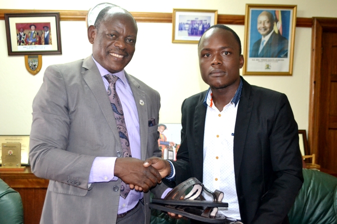 Joseph Kayongo presenting the gift to the Vice Chancellor.