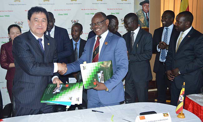 Prof. Sui Guangjun - President of Guangdong University of Foreign Studies (Left)  and Vice Chancellor Prof. Barnabas Nawangwe shake hands after signing the MoU amidst witnesses from both institutions on 17th May 2018 in the Council Room, Makerere University, Kampala Uganda.