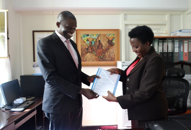 The Outgoing University Bursar, Mr. Augustine Tamale handing over office to the Acting University Bursar, Ms. Deborah Nalule.