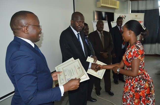 One of the participants receiving a certificate from the Deputy Vice Chancellor for Academic Affairs, Dr. Ernest Okello Ogwang.